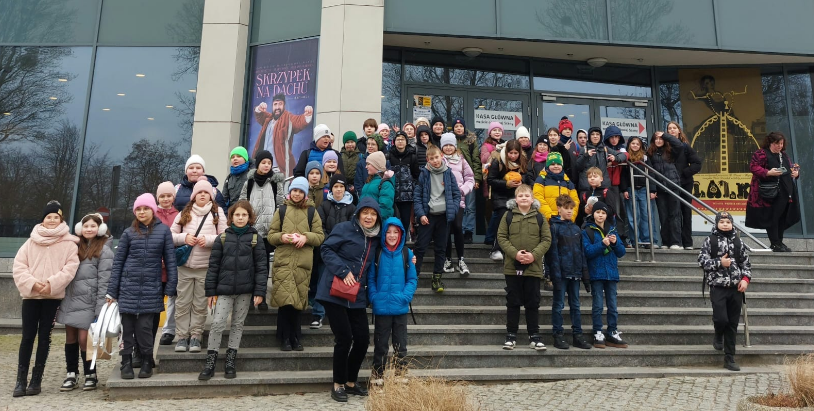 Uczniowie stoją na schodach przed teatrem muzycznym w Gdyni